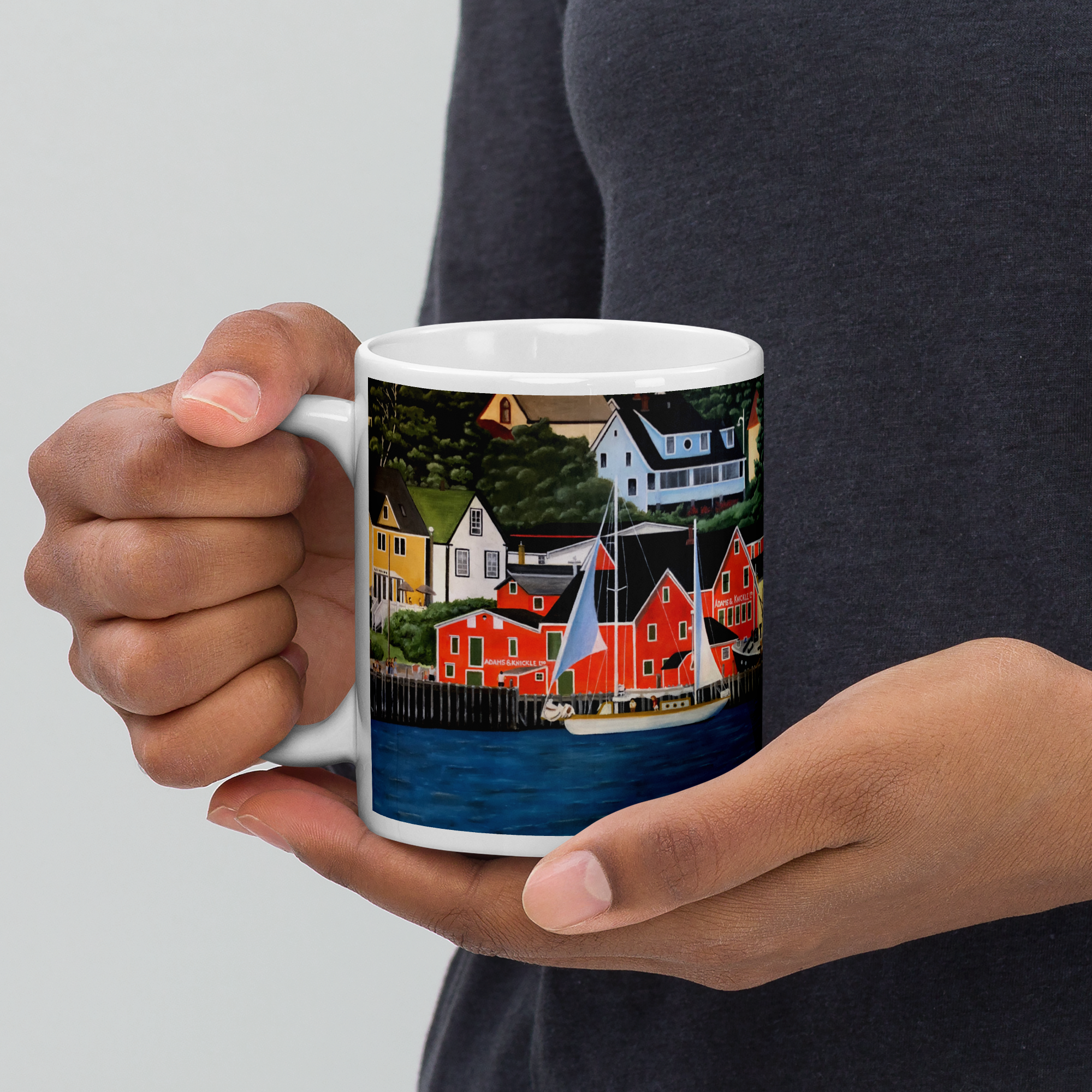 Painting on a Mug - A sailboat is slowly sailing by the Lunenberg harbor, with the fishing wharft and community of Lunenberg in the background.
